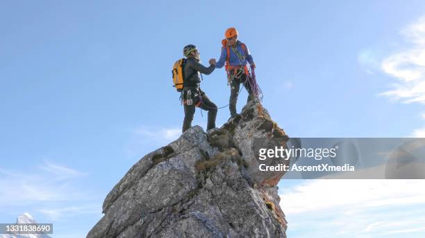 bergsteiger high five auf berggipfel - success stock-fotos und bilder