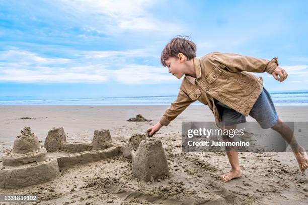 little boy playing with sand castles at the beach - sand castle bildbanksfoton och bilder