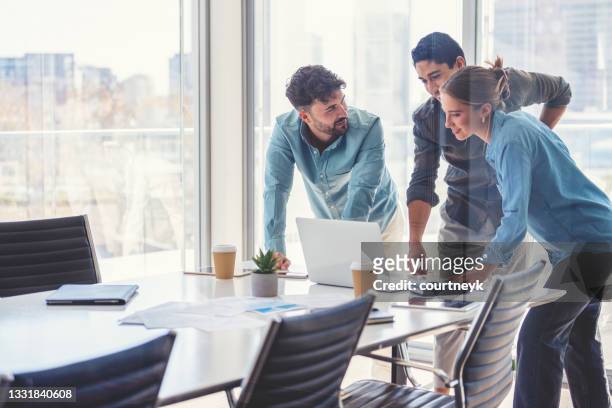 team aziendale che lavora su un computer portatile. - business meeting foto e immagini stock