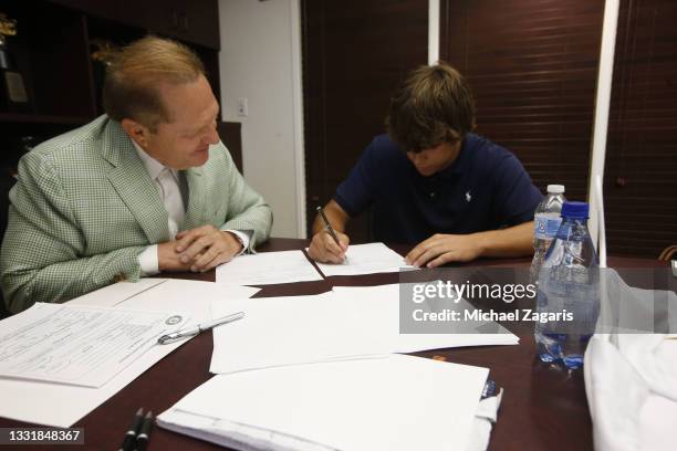 Oakland Athletics 2021 first round draft pick Max Muncy signs his contract with agent Scott Boras before the game between the Athletics and the Los...