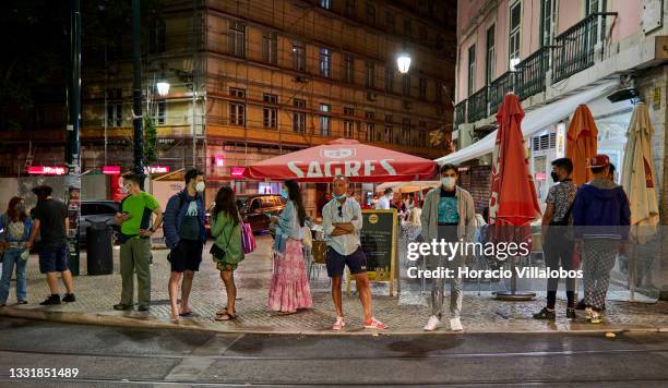 Pedestrians wait to cross Rua do Alecrim, Cais do Sodre, on the day of the end of traffic restrictions after 11pm, and commerce, restaurants and...