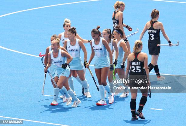 Team Argentina celebrates scoring their third goal while Amelie Wortmann and Viktoria Huse of Team Germany look on during the Women's Quarterfinal...