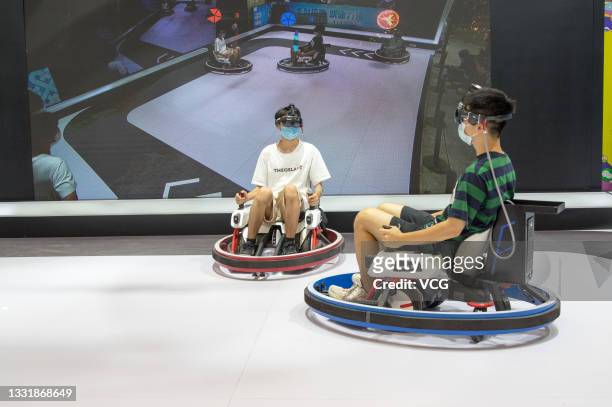 Visitors play VR driving game during the 19th China Digital Entertainment Expo & Conference is held at Shanghai New International Expo Centre on July...