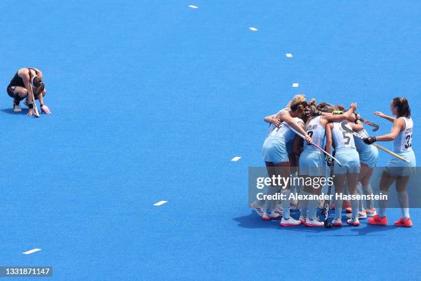 Team Argentina huddles up after their 3-0 win while Franzisca Hauke of Team Germany reacts to the loss during the Women's Quarterfinal match between...