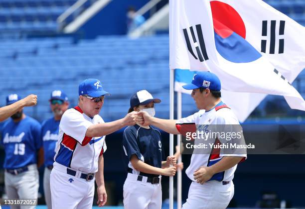 Hyunsoo Kim of Team South Korea gets a fist bump from team manager Kyungmoon Kim as he takes the field for pregame ceremonies against Team Israel...
