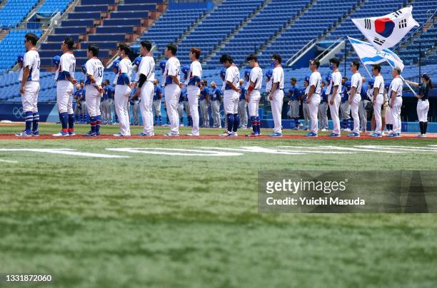 Team South Korea stand on the base line for pregame ceremonies before the game against Team Israel during the knockout stage of men's baseball on day...