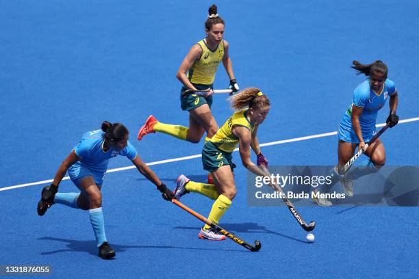 Ambrosia Malone of Team Australia moves the ball past Neha Neha and Gurjit Kaur of Team India during the Women's Quarterfinal match between Australia...