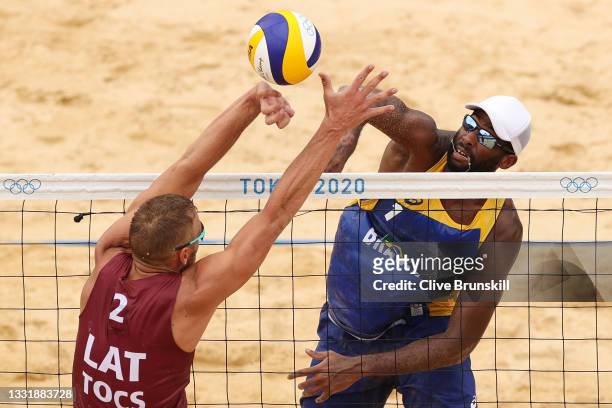 Evandro Goncalves Oliveira Junior of Team Brazil strikes against Team Latvia during the Men's Round of 16 beach volleyball on day ten of the Tokyo...