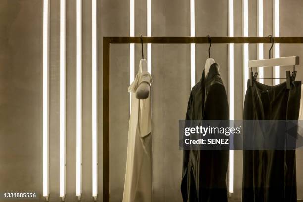 close-up of clothes hanging on window at store - high end fashion stock pictures, royalty-free photos & images