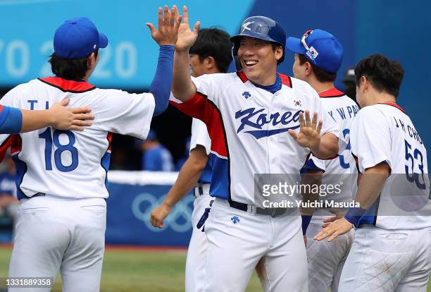 Hyunsoo Kim of Team South Korea celebrates with teammates after scoring in the seventh inning against Team Israel during the knockout stage of men's...