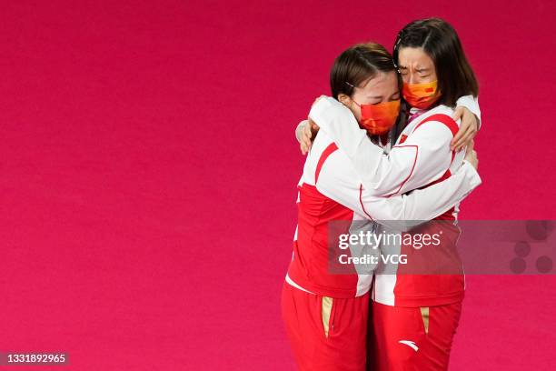 Silver medalists Chen Qingchen and Jia Yifan of China hug on the podium during the medal ceremony for the Women's Doubles badminton event on day ten...