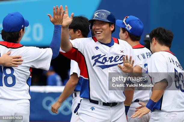 Hyunsoo Kim of Team South Korea celebrates with teammates after scoring in the seventh inning against Team Israel during the knockout stage of men's...