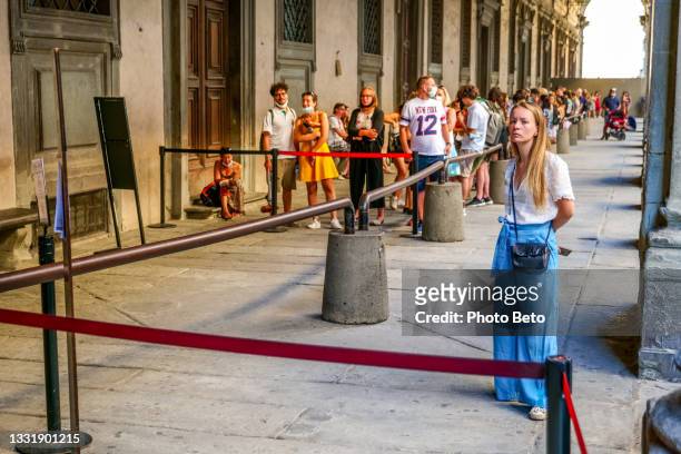 dozens of tourists wait in line to visit the uffizi gallery in the renaissance heart of florence in tuscany - uffizi museum stock pictures, royalty-free photos & images