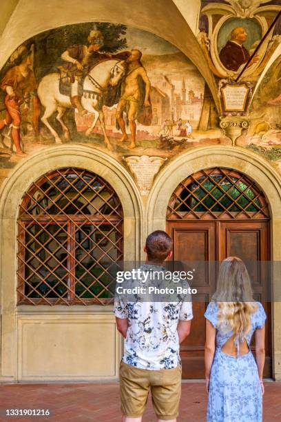 a couple of young tourists admire the frescoes in the cloister of the ognissanti abbey church in the heart of florence - court notice stock pictures, royalty-free photos & images