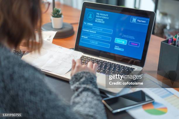 woman using laptop computer pay utility  bill, financial technology internet banking concept - bill assistance stock pictures, royalty-free photos & images