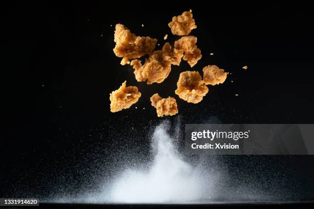 fried chicken meat flying in mid air captured with high speed sync. - crunchy food stock pictures, royalty-free photos & images