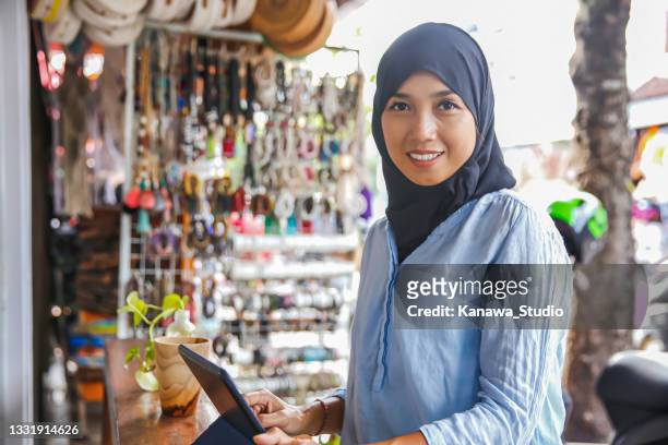 portrait shot of a smiling indonesian gift shop owner - indonesia stock pictures, royalty-free photos & images