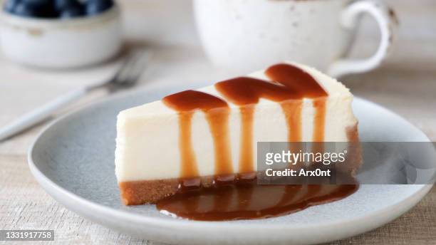 slice of cheesecake with caramel sauce - cheesecake stock-fotos und bilder