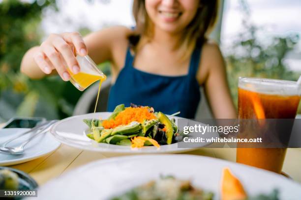 young woman eating vegan food at restaurant - garden salad stock pictures, royalty-free photos & images