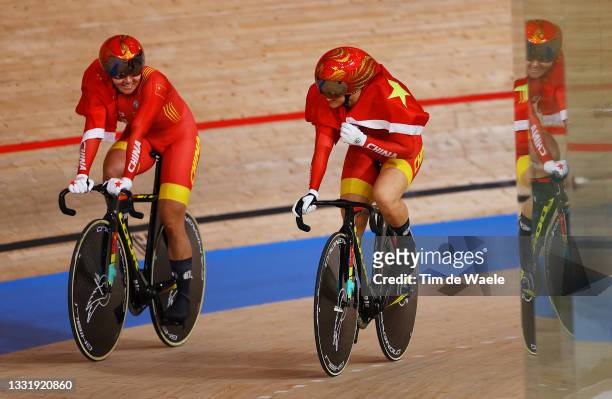 Tianshi Zhong and Shanju Bao of Team China celebrate winning the gold medal while holding the flag of they country after the Women's team sprint...