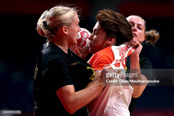 Petra Vamos of Team Hungary is challenged by Emma Lindqvist and Kristin Thorleifsdottir of Team Sweden during the Women's Preliminary Round Group B...