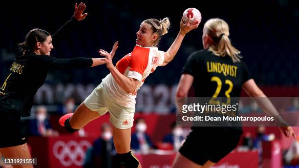 Noemi Hafra of Team Hungary shoots at goal as Carin Stromberg of Team Sweden defends during the Women's Preliminary Round Group B handball match...