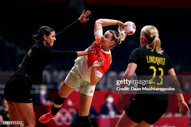 Noemi Hafra of Team Hungary shoots at goal as Carin Stromberg of Team Sweden defends during the Women's Preliminary Round Group B handball match...