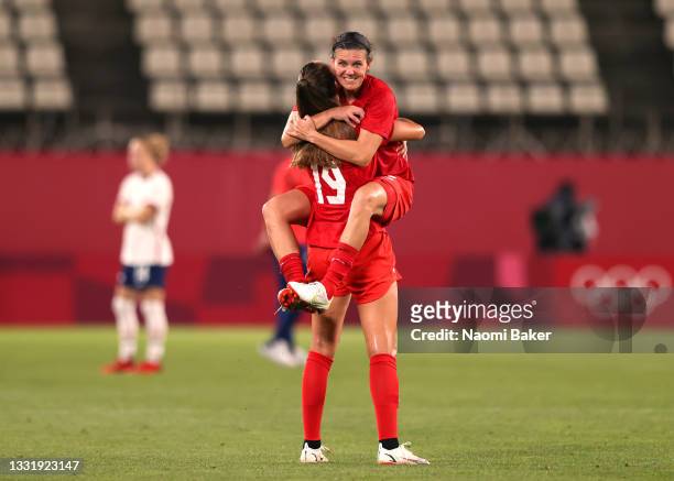 Christine Sinclair of Team Canada jumps on team mate Jordyn Huitema of Team Canada following their side's victory in the Women's Semi-Final match...