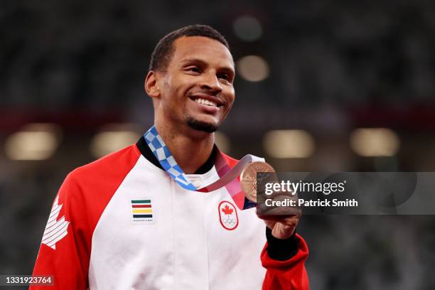 Bronze medalist Andre De Grasse of Team Canada holds up his medal on the podium during the medal ceremony for the Men's 100m on day ten of the Tokyo...