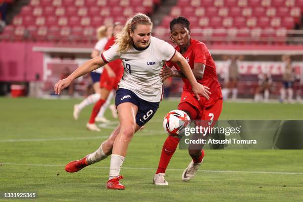 Lindsey Horan of Team United States battles for possession with Kadeisha Buchanan of Team Canada during the Women's Semi-Final match between USA and...