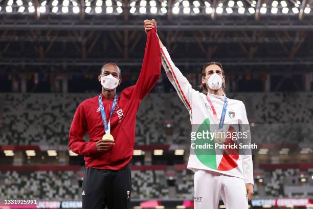 Joint gold medalists Mutaz Essa Barshim of Team Qatar and Gianmarco Tamberi of Team Italy celebrate on the podium during the medal ceremony for the...