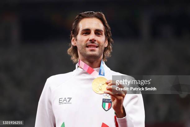 Joint gold medalist Gianmarco Tamberi of Team Italy holds up his medal on the podium during the medal ceremony for the Men's High Jump on day ten of...