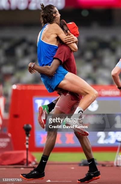 Gianmarco Tamberi of Team Italy and Mutaz Essa Barshim of Team Qatar react after winning the gold medal in the men's High Jump on day nine of the...