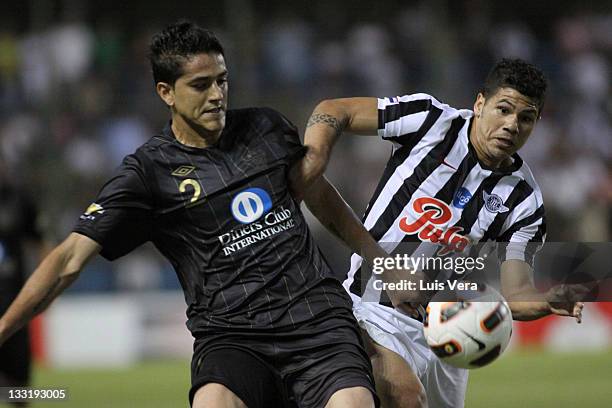 Norberto Araujo, from Liga Universitaria de Quito, fights for the ball with Robin Ramirez, from Libertad, during a match between Liga Universitaria...