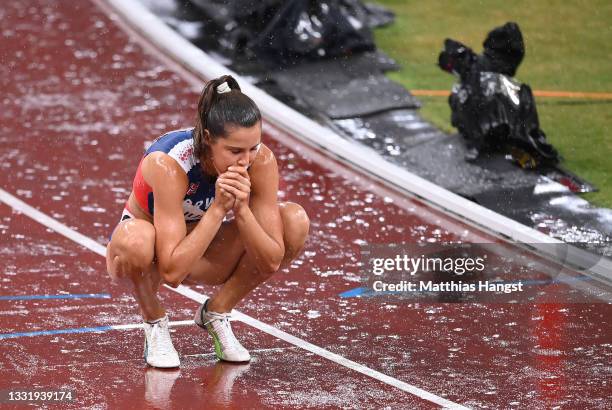 Amalie Iuel of Team Norway attempts to keep warm as rain falls prior to the Women's 400 metres hurdles semi finals on day ten of the Tokyo 2020...