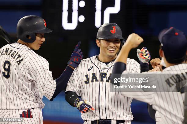 Seiya Suzuki of Team Japan returns to the dugout after hitting a solo home run in the fifth inning during the knockout stage of men's baseball on day...