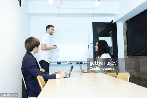 caucasian teacher with international students - japanese people lesson english stock pictures, royalty-free photos & images