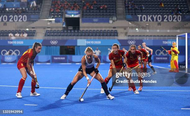 Hannah Martin of Team Great Britain controls the ball whilst under pressure from Team Spain defense during the Women's Quarterfinal match between...