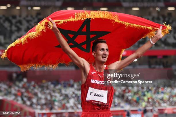 Soufiane El Bakkali of Team Morocco celebrates with his countries flag after winning gold in the Men's 3000 metres Steeplechase Final on day ten of...