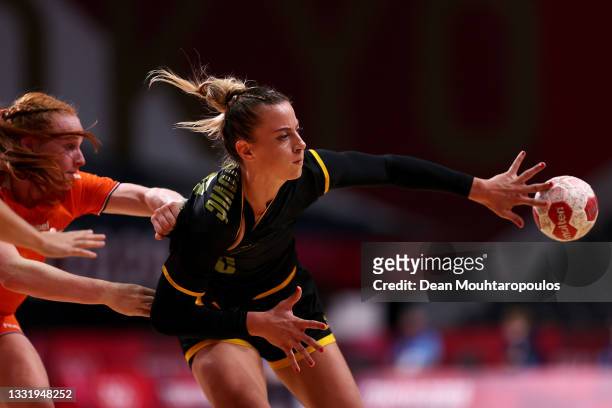 Jelena Despotovic of Team Montenegro passes the ball while being challenged by Dione Housheer of Team Netherlands during the Women's Preliminary...