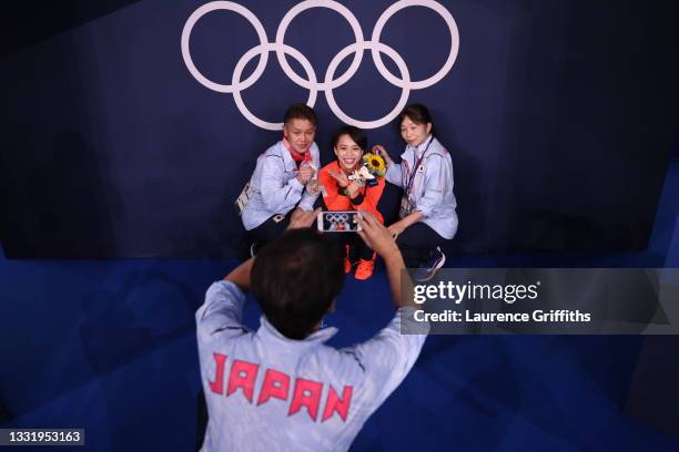 Mai Murakami of Team Japan poses with her bronze medal and coaches on day ten of the Tokyo 2020 Olympic Games at Ariake Gymnastics Centre on August...