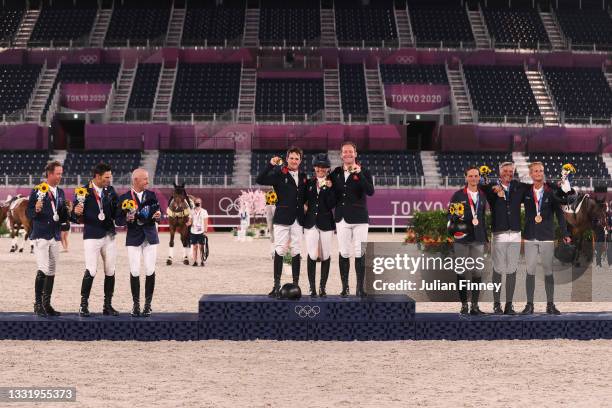 Silver medalists Team Australia, gold medalists Team Great Britain and bronze medalists Team France pose on the podium during the Eventing Jumping...