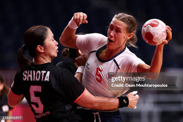 Marit Malm Frafjord of Team Norway is challenged by Sayo Shiota of Team Japan during the Women's Preliminary Round Group A handball match between...