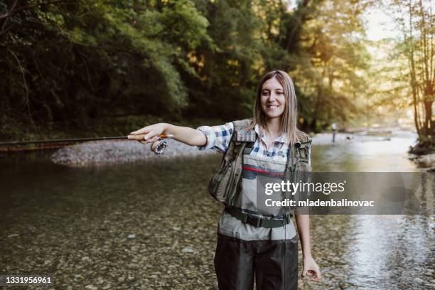 young adult couple is fishing together on fast mountain river. active people and sport fly fishing concept. - fly casting imagens e fotografias de stock