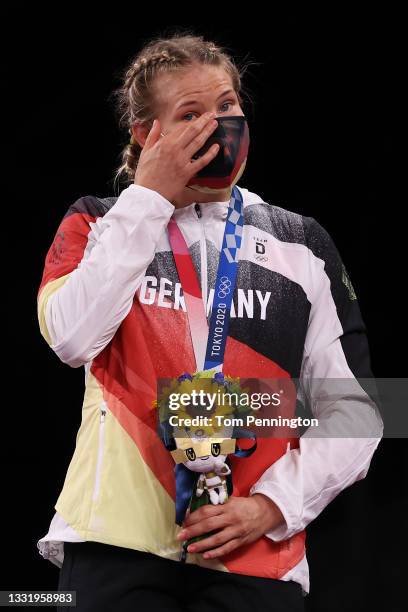 Women's Freestyle 76kg gold medalist Aline Rotter Focken of Team Germany wipes tears from her eyes during the Victory Ceremony on day ten of the...