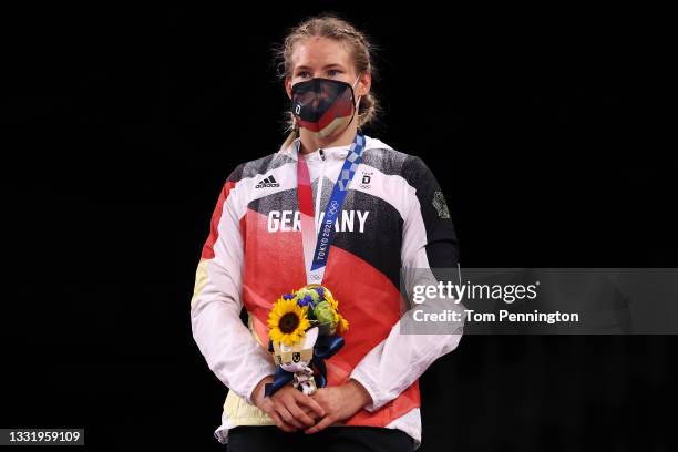 Women's Freestyle 76kg gold medalist Aline Rotter Focken of Team Germany stands for the national anthem during the Victory Ceremony on day ten of the...