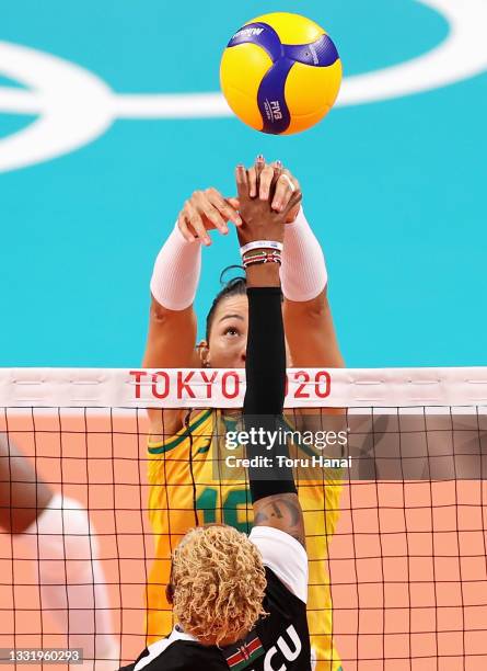 Ana Carolina da Silva of Team Brazil grabs the hand of Jane Wacu Wairimu of Team Kenya during the Women's Preliminary - Pool A volleyball on day ten...