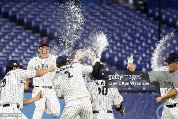Team Japan celebrates after Takuya Kai hit a game-winning single in the tenth inning to defeat Team United States 7-6 during the knockout stage of...
