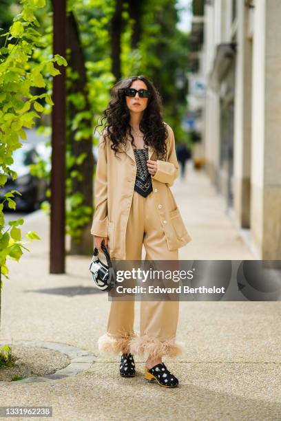 Gabriella Berdugo wears square sunglasses from Valentino, a beige Pyjama suit with feathers details at hems from Sleepers, a vintage scarf / foulard...