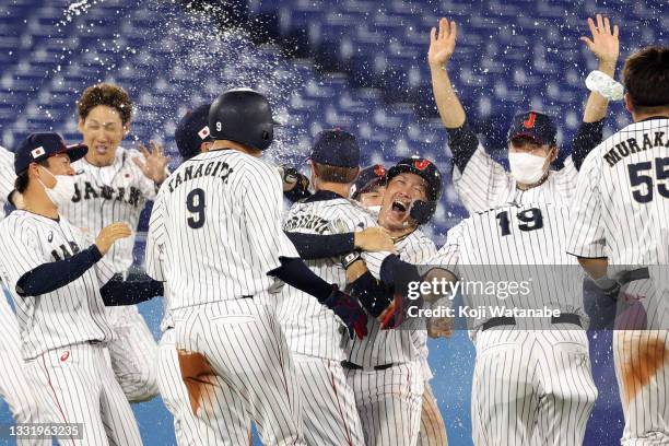 Takuya Kai of Team Japan celebrates with his teammates after hitting a game-winning single in the tenth inning to defeat Team United States 7-6...